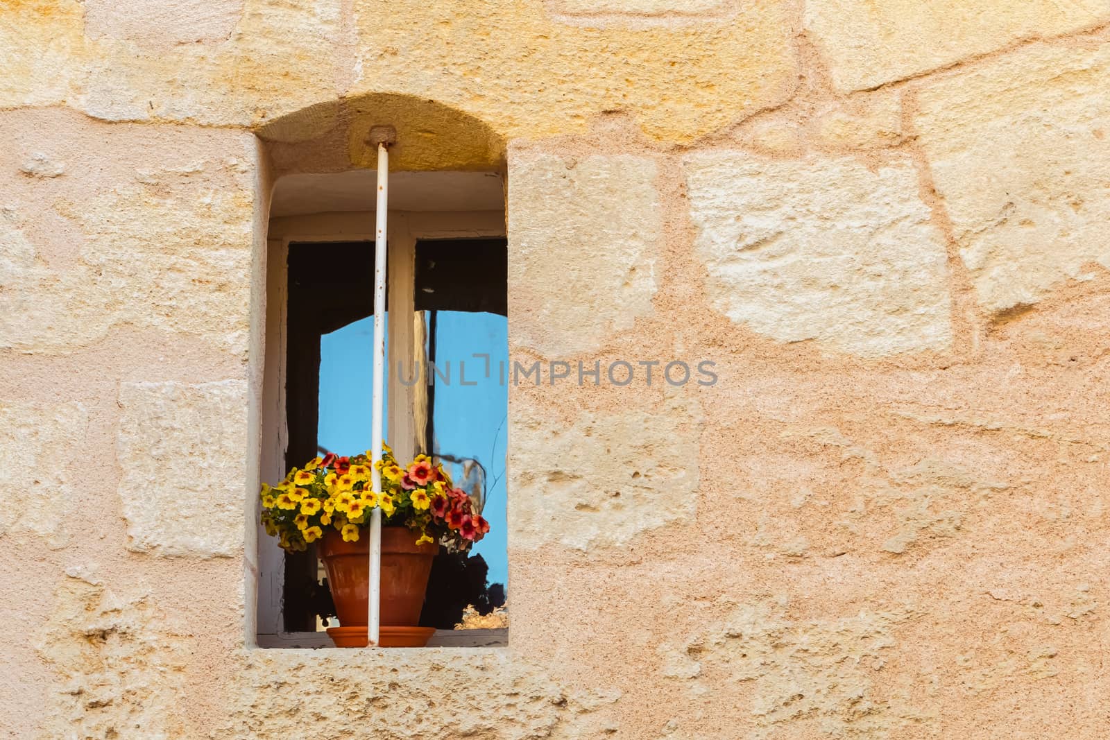 stone wall with an old window and yellow flower pot by AtlanticEUROSTOXX