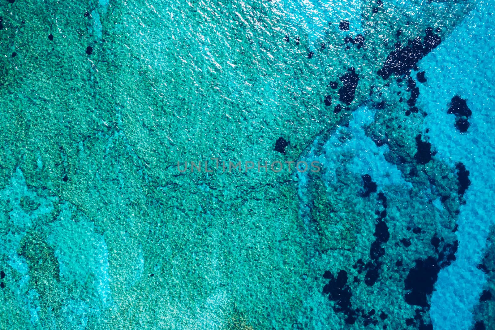 Sea surface aerial view. Background image of the turquoise sea. Deep sea and corals. Aerial drone shot of turquoise water, space for text. Aquamarine background. Sea Aerial view.