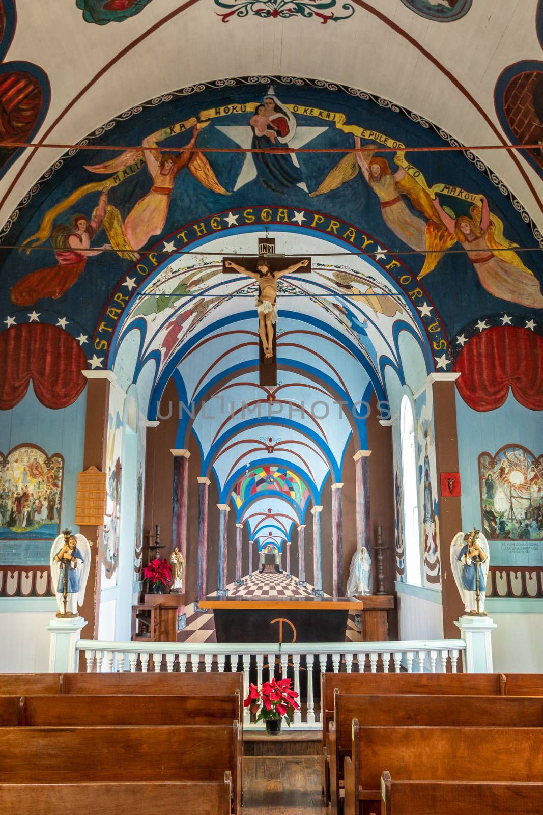 Kalapana, Hawaii, USA. - January 14, 2020: Mary, Star of the Sea Catholic Church. Chancel with altar and back wall painted as a far visual effect. Walls and ceilings adorned with paintings. Large cross.