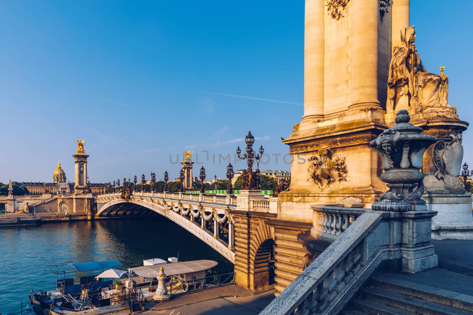 Pont Alexandre III bridge over river Seine in the sunny summer morning. Bridge decorated with ornate Art Nouveau lamps and sculptures. The Alexander III Bridge across Seine river in Paris, France.