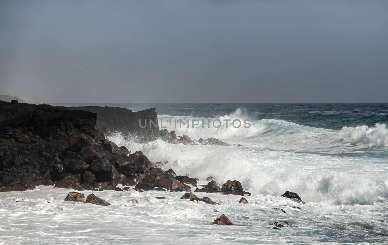 Azure wave crashes on black lava coast on Kaimu Beach, Hawaii, U by Claudine