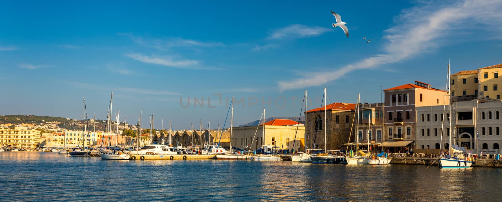 Old port of Chania with flying seagulls. Landmarks of Crete island. Bay of Chania at sunny summer day, Crete Greece. View of the old port of Chania, Crete, Greece. The port of chania, or Hania. 
