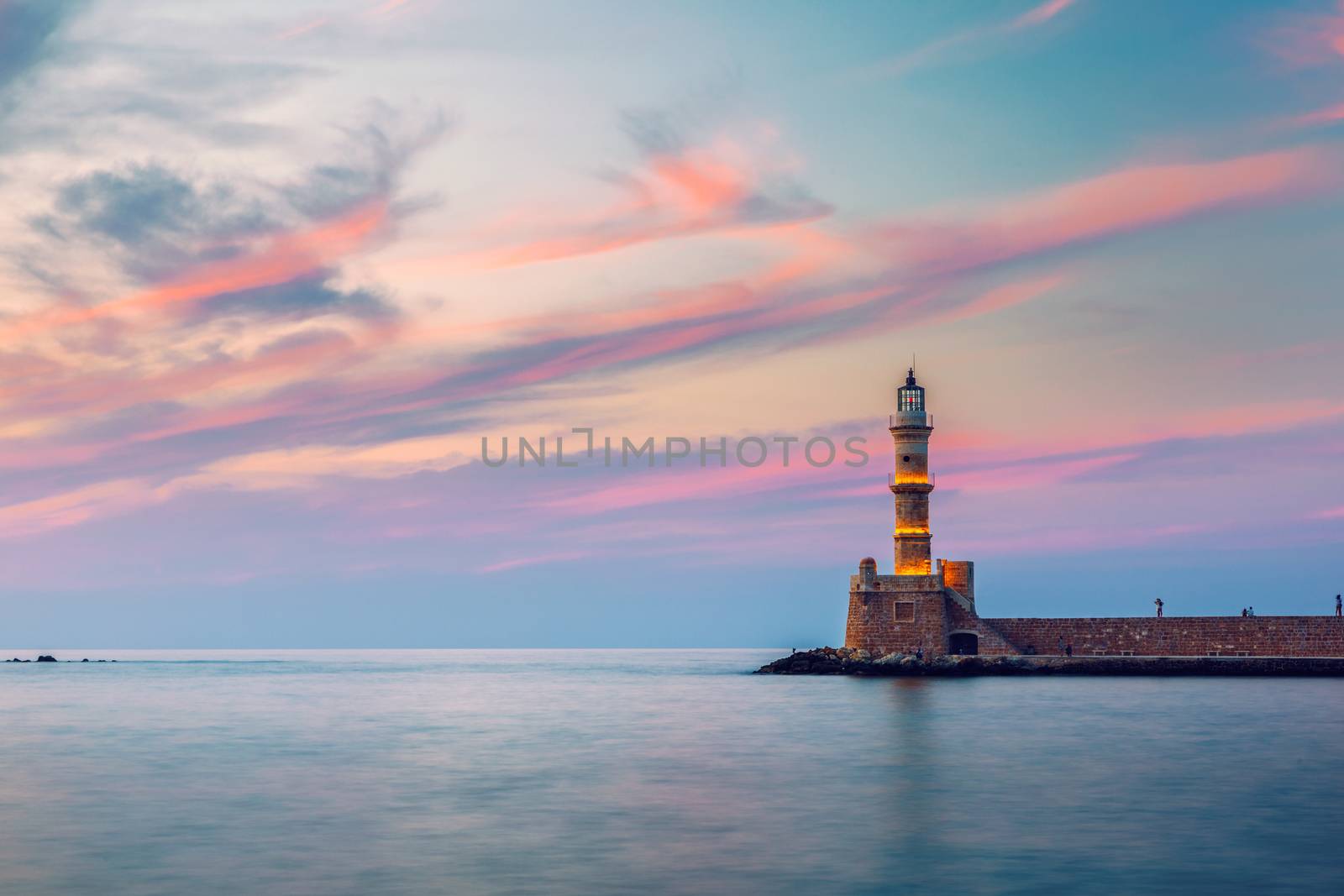 Venetian harbour and lighthouse in old harbour of Chania at sunset, Crete, Greece. Old venetian lighthouse in Chania, Greece. Lighthouse of the old Venetian port in Chania, Greece.