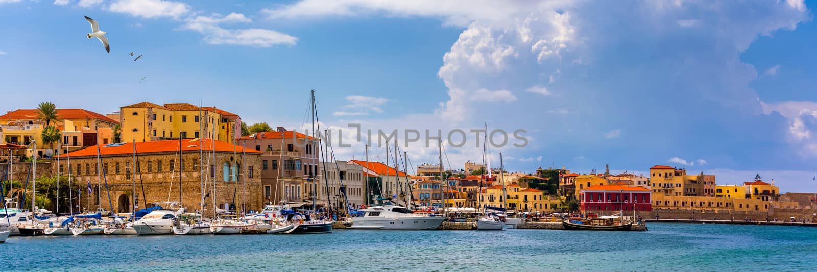 Old port of Chania with flying seagulls. Landmarks of Crete island. Bay of Chania at sunny summer day, Crete Greece. View of the old port of Chania, Crete, Greece. The port of chania, or Hania. 
