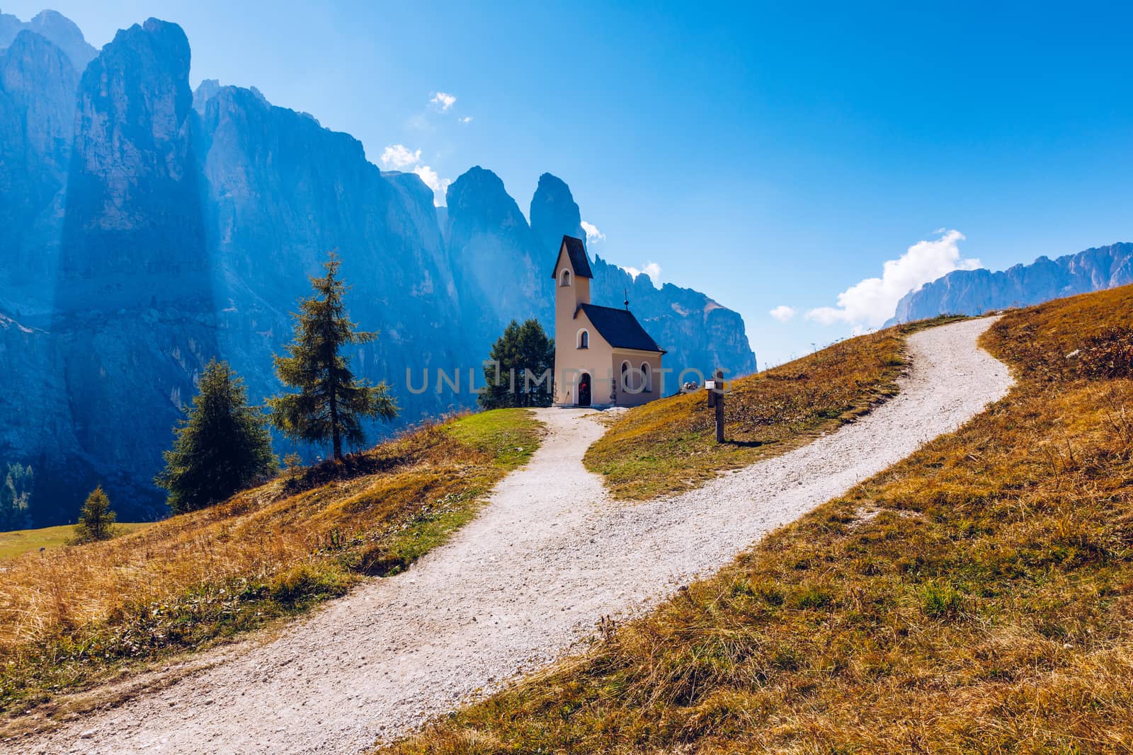 Chapel of San Maurizio at Passo Gardena, South Tyrol, Italy.  View to path to small white chapel San Maurizio and Dolomiti mountain. San Maurizio chapel on the Gardena Pass, South Tyrol, Italy.