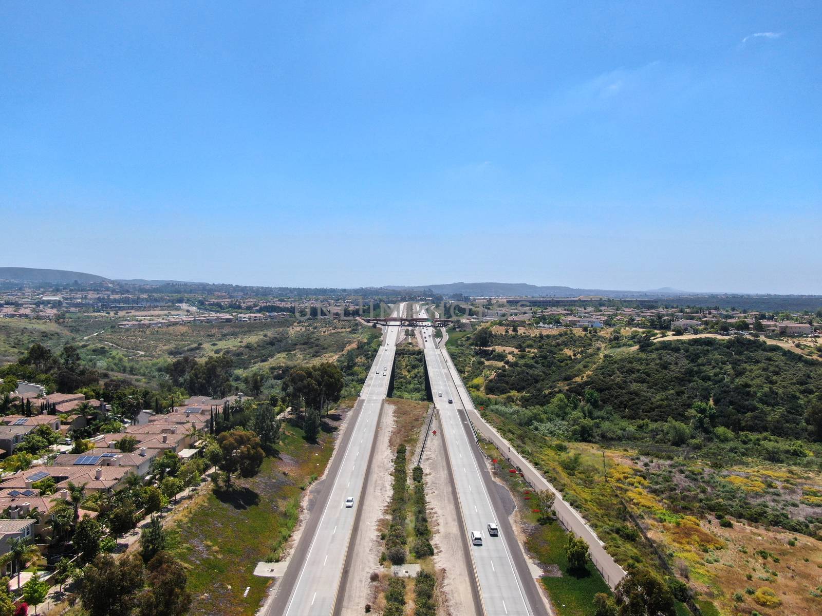 Aerial view of highway, freeway road with vehicle in movement with blue sky baclground, California, USA.