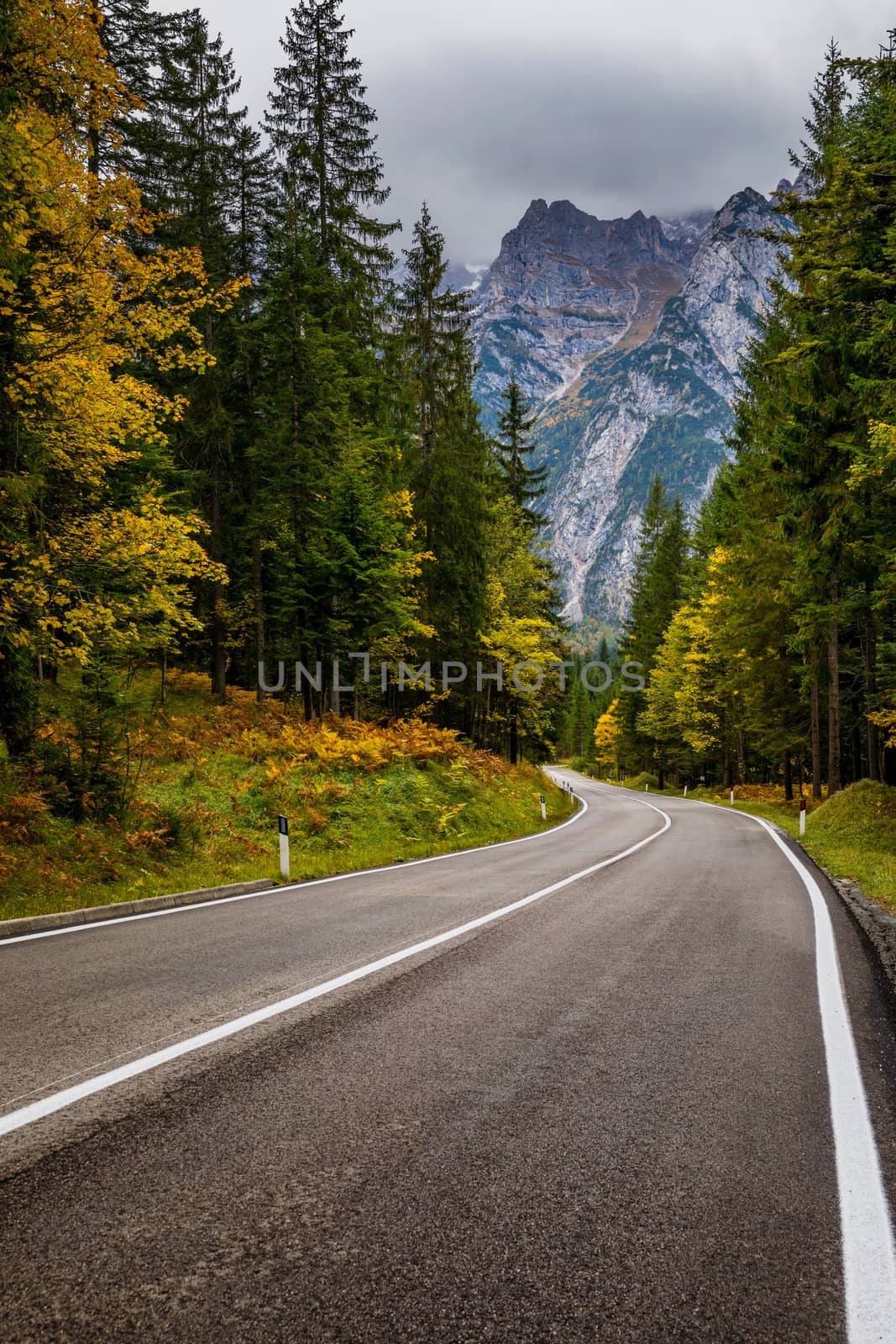 Mountain road. Landscape with rocks, sunny sky with clouds and beautiful asphalt road in the evening in summer. Vintage toning. Travel background. Highway in mountains.  
