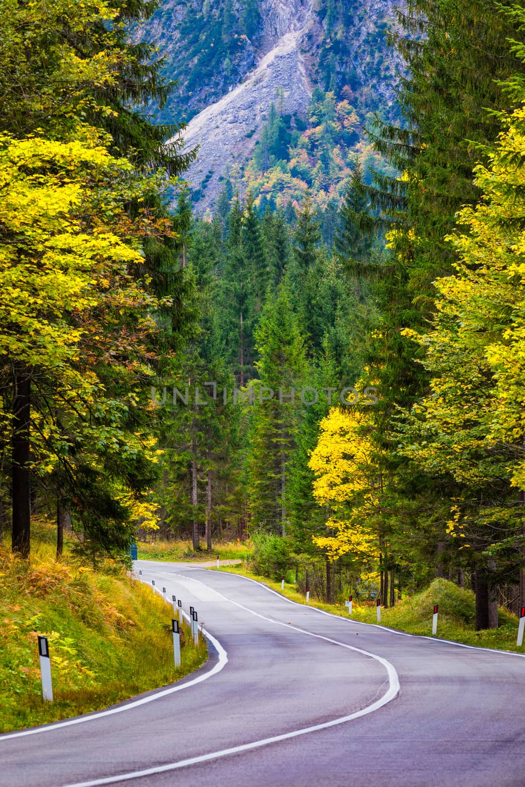 Mountain road. Landscape with rocks, sunny sky with clouds and beautiful asphalt road in the evening in summer. Vintage toning. Travel background. Highway in mountains.  