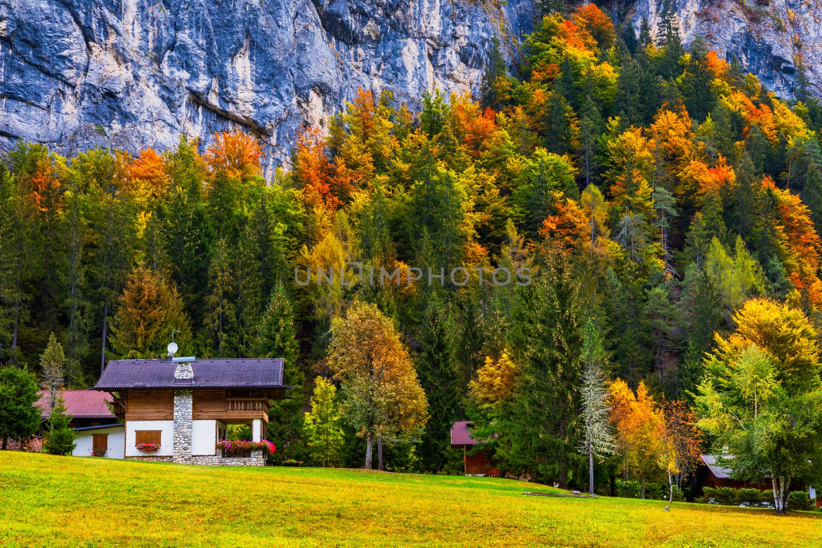 Autumn in the famous Dolomites mountains, Italy, Europe. Dramatic cliffs surround the village with the the iconic mountains and autumn forest. Colorful autumn landscape in mountain village. 