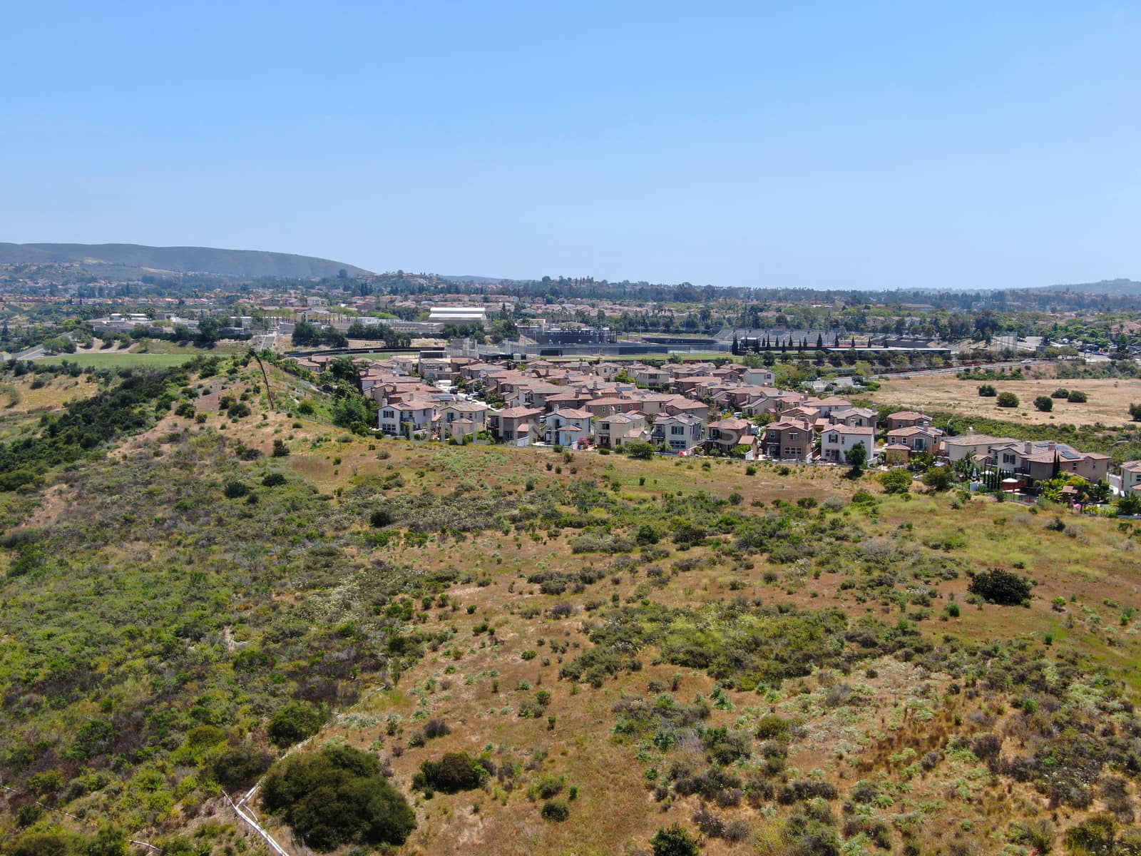 Aerial view of upper middle class neighborhood with residential houses in green valley, South California, USA.