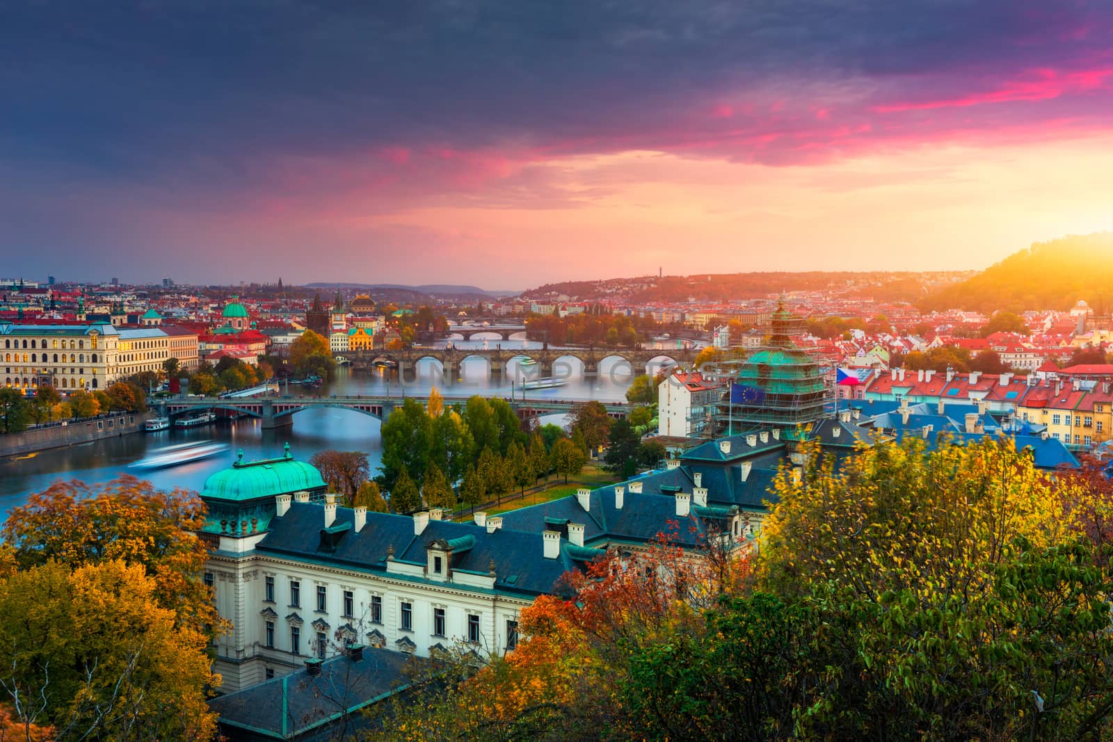 Autumn view to Charles bridge on Vltava river in Prague, Czech Republic. Autumn view to Charles Bridge, Prague old town and Vltava river from Letna park (Letenske sady) at sunset with colorful sky.