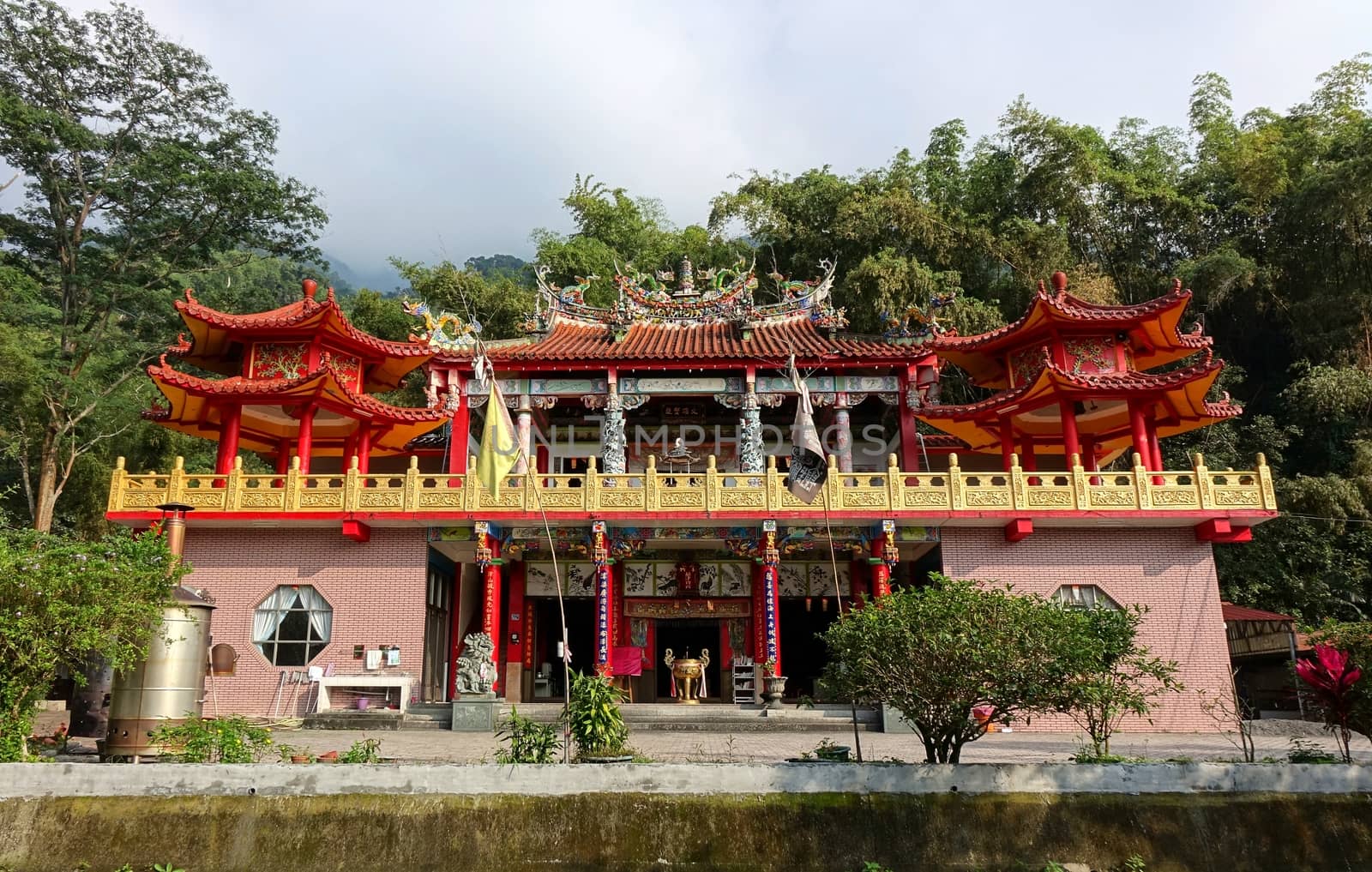 PINGTUNG, TAIWAN -- FEBRUARY 5, 2016: The Baolian Temple with its decorated column and a large bronze incense burner is nestled in the foothills of the Pingtung Mountains.