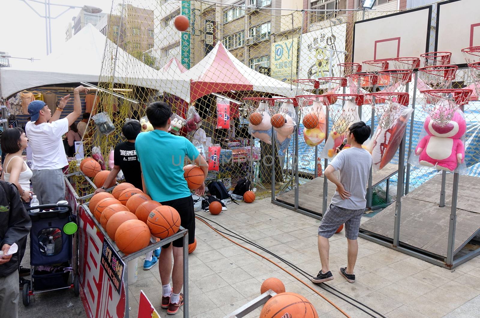 KAOHSIUNG, TAIWAN -- FEBRUARY 6, 2019: People try to score basketball hits in a skill game at a Chinese New Year Market.
