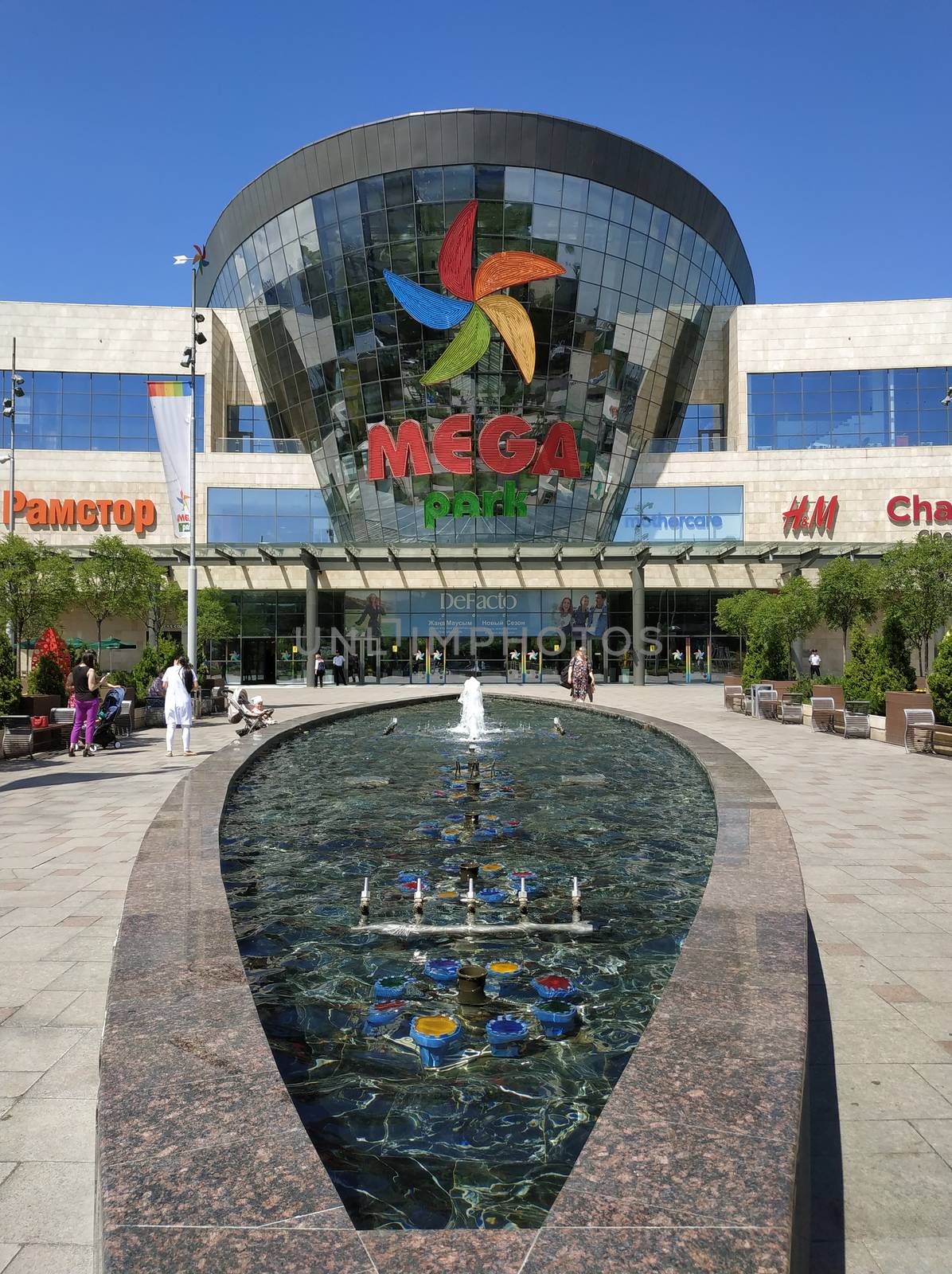 ALMATY, KAZAKHSTAN - June 15, 2019: Shopping and entertainment center Mega Park in Almaty, Kazakhstan. Opened in 2015, it is the largest department store in Almaty. Unidentified people are outside.