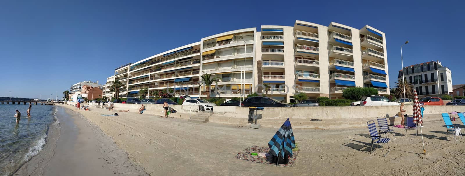 Cannes, France - July 8, 2018: Public beach at the end of the Promenade de la Croisette. Unidentified people relax on the beach.