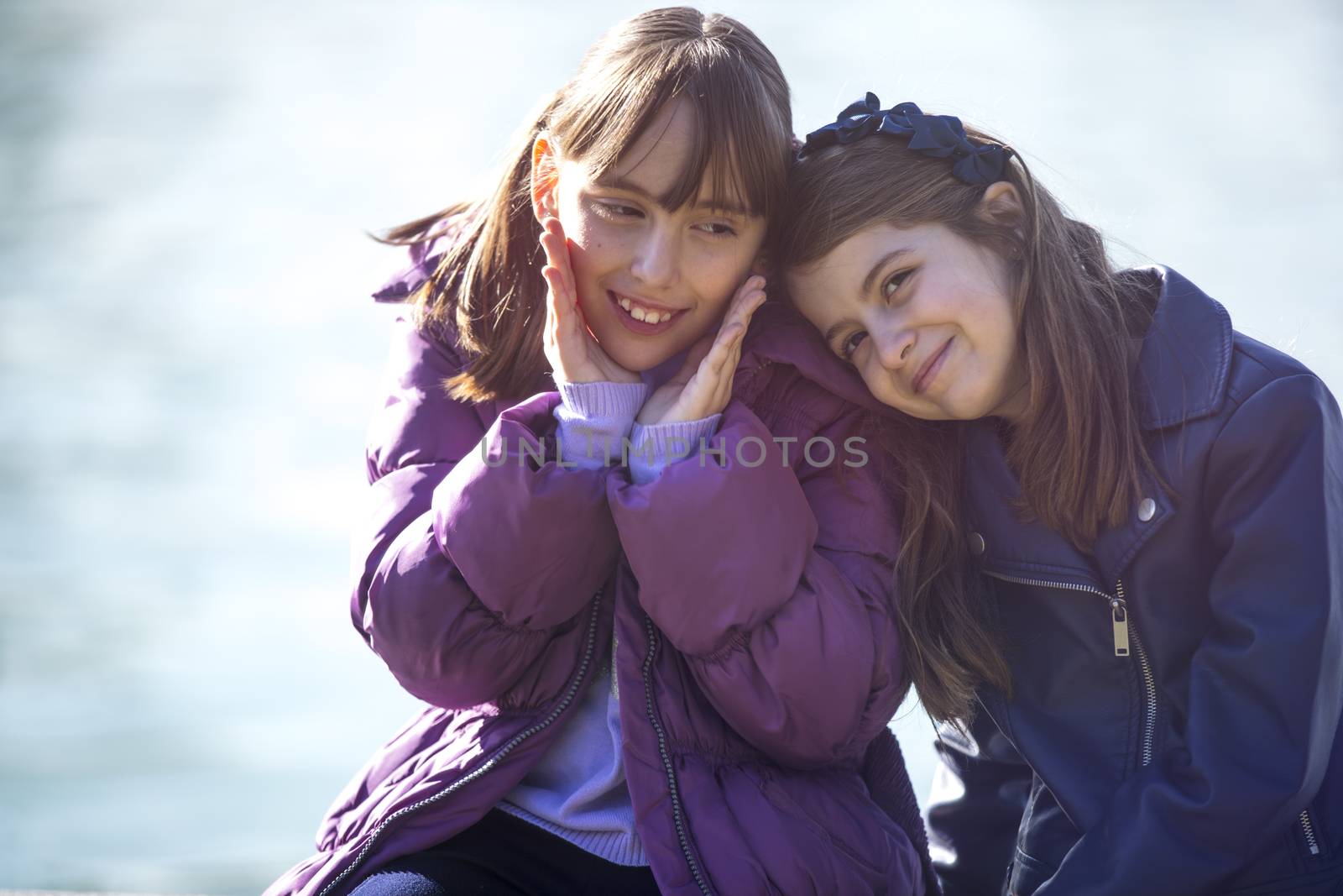 Two girlfriends having fun in a public park in the fall.