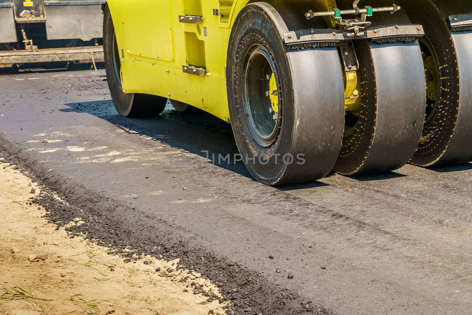 asphalt roller works on the road on a sunny day