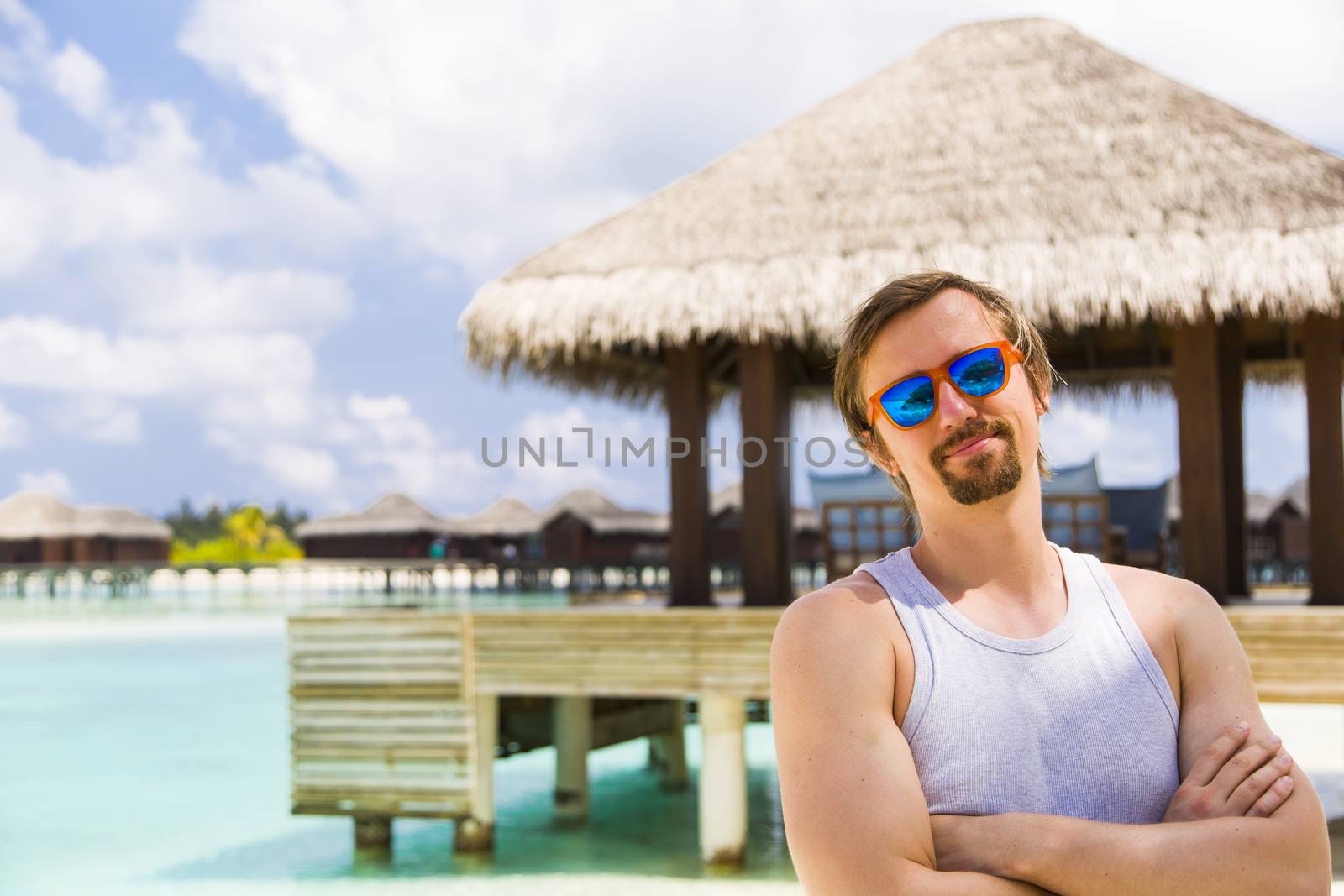 Man in Front of a Over Water Bungalow in Paradise by Nemida