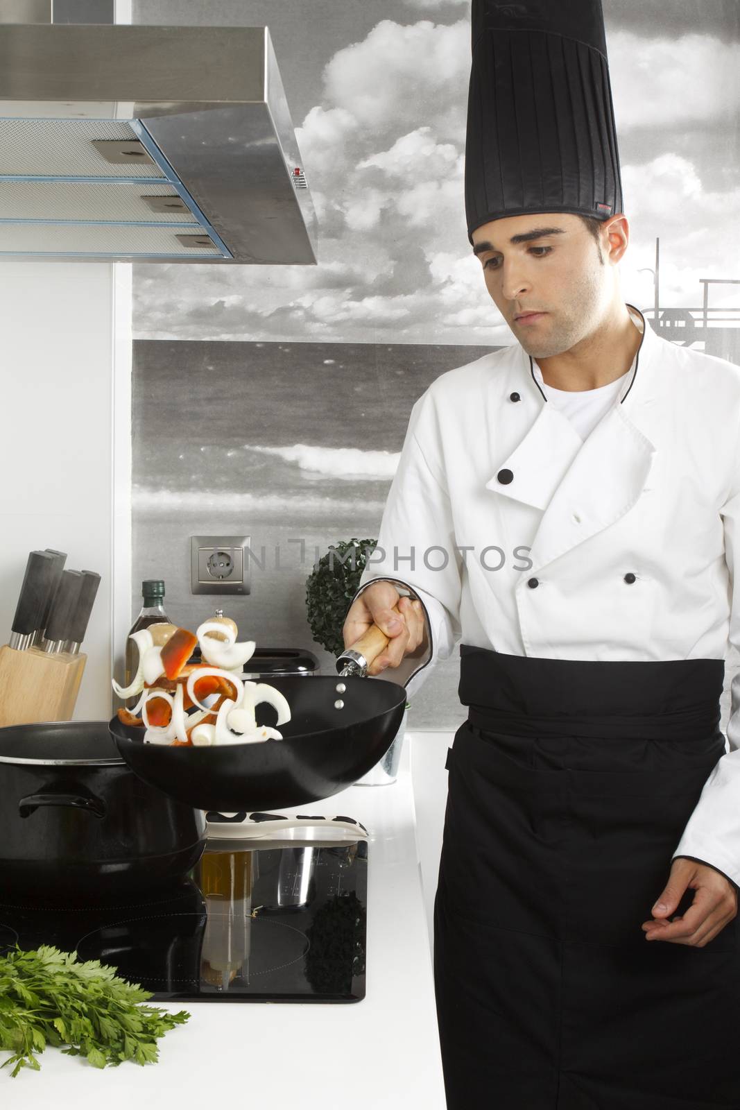 Chef juggling onions and red peppers.