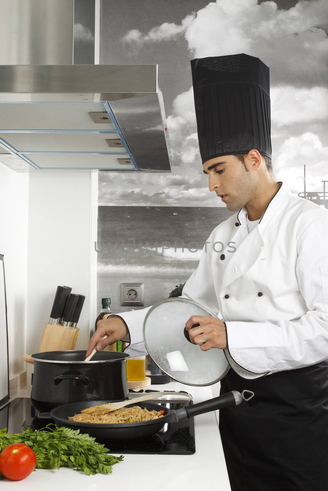 Chef stirring with spoon in pot.