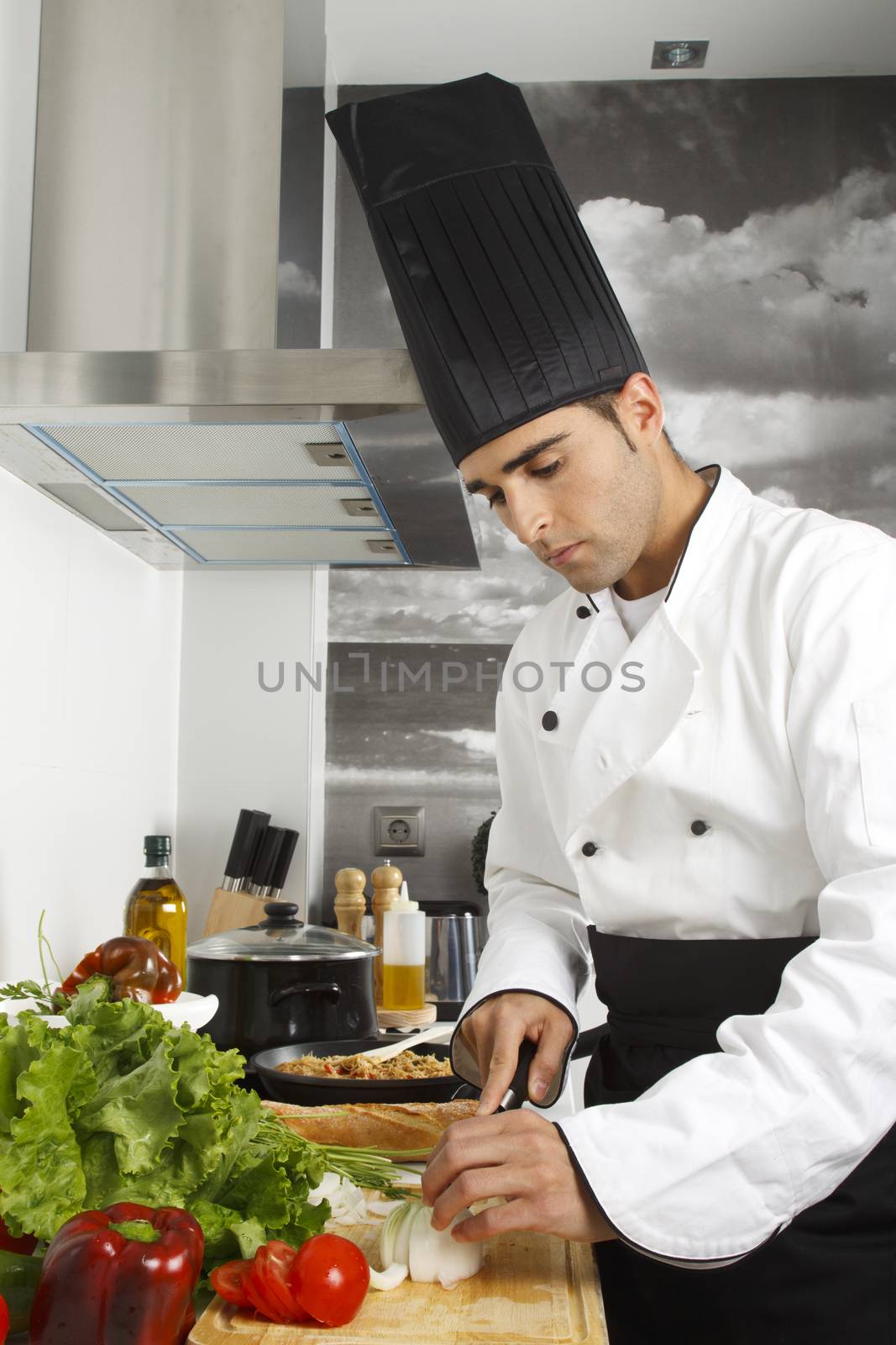 Chef chopping onions on cutting board.