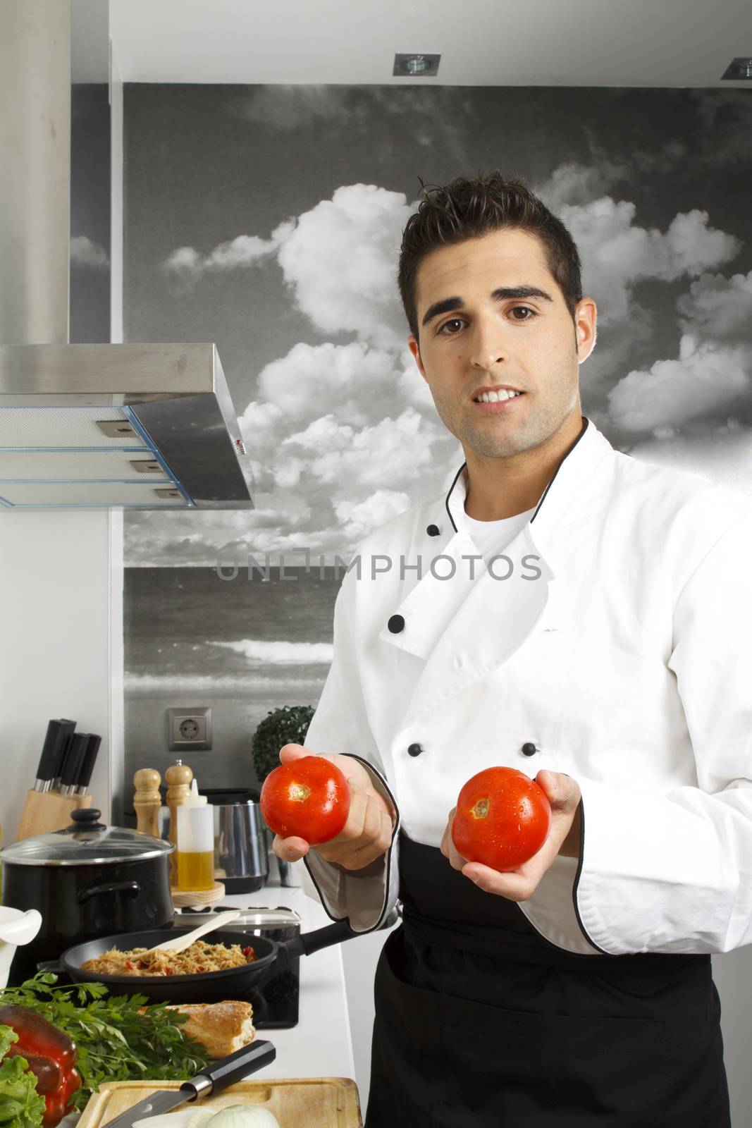Proud chef showing two beautiful tomatoes.