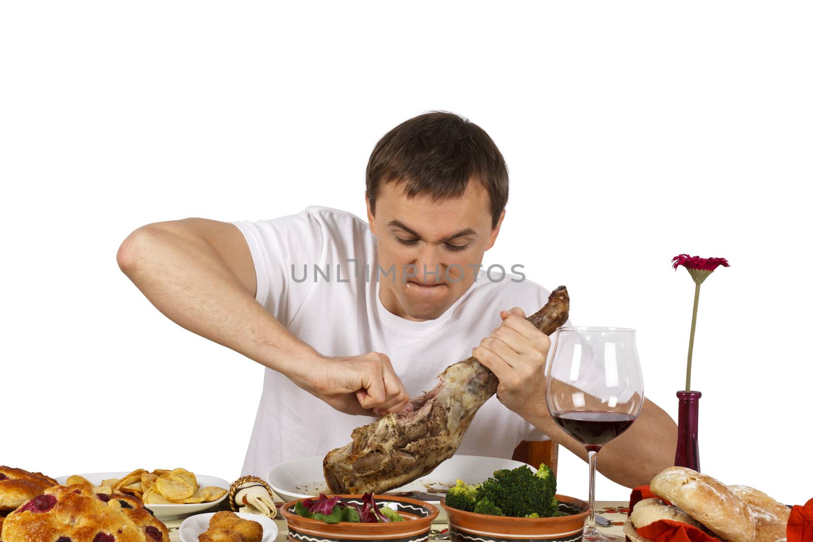 Young man pulling out a part of leg of lamb. Isolated of white background.