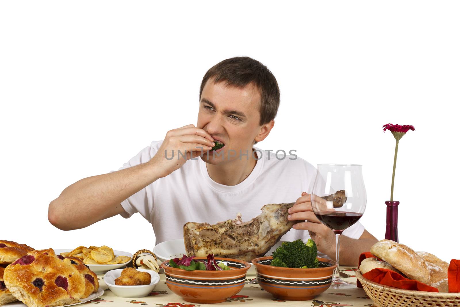 Young man eating a broccoli. Isolated of white background.