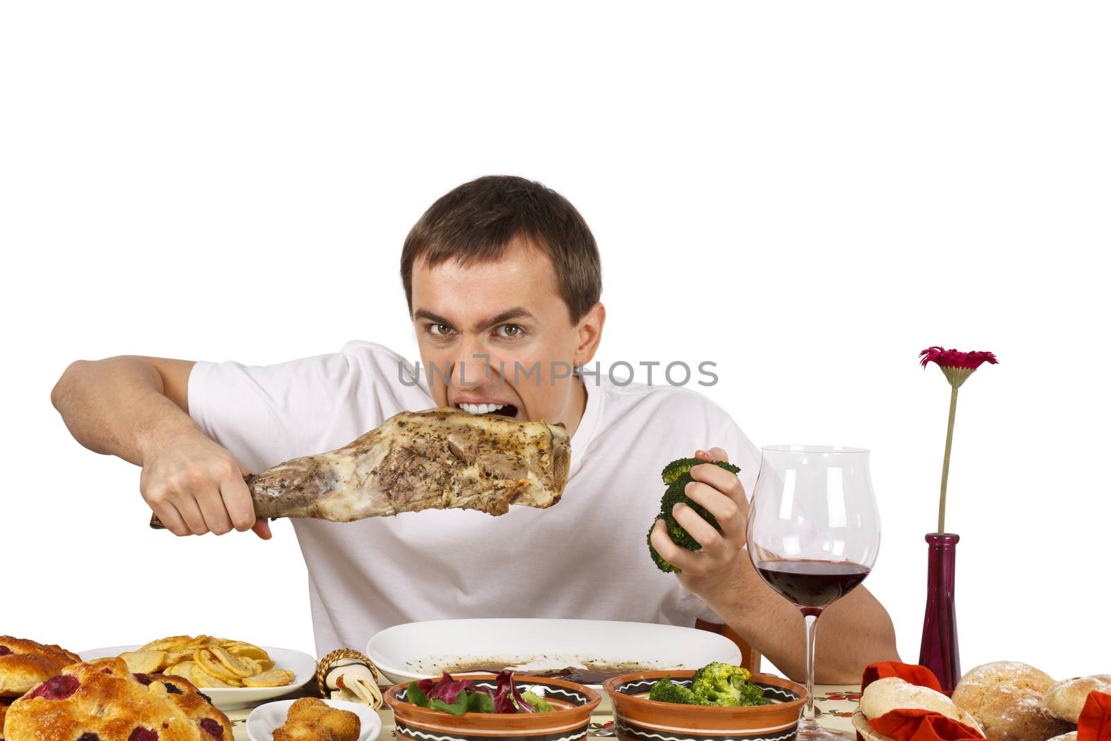 Bad mannered young man eating a leg of lamb. Isolated of white background.