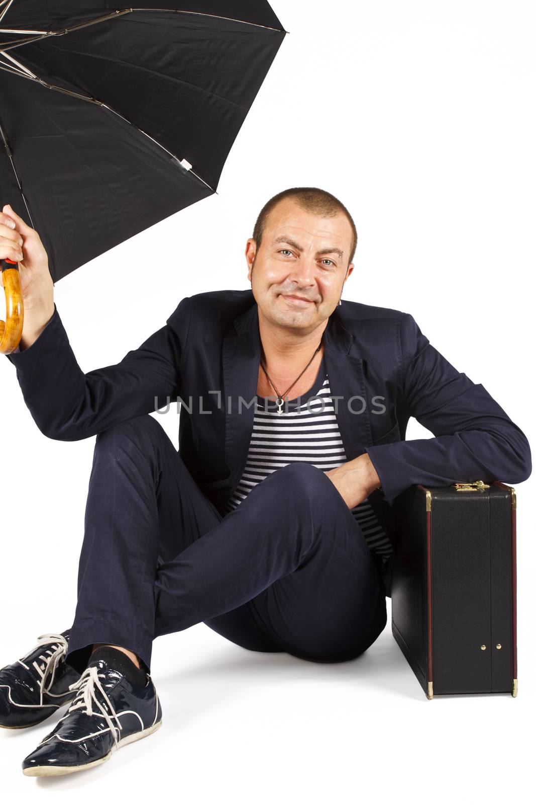 Man sitting on floor resting on briefcase. Over white.