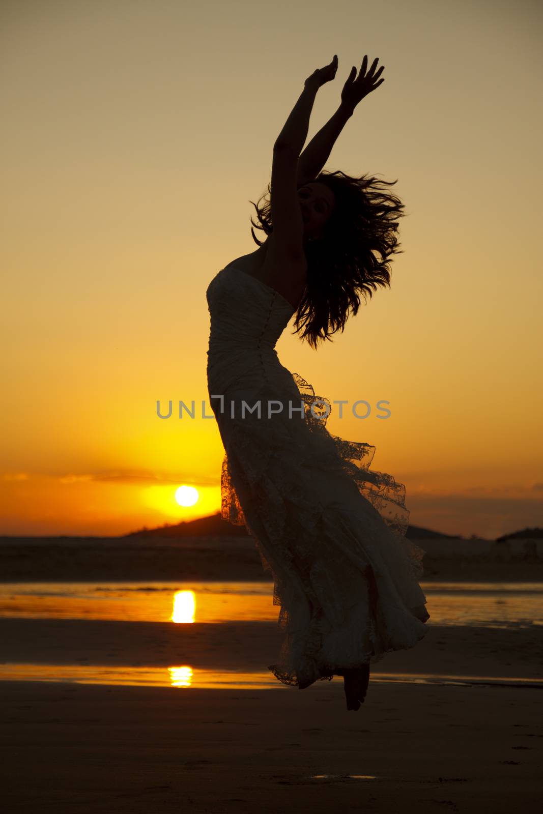 Bride jumping at sunset. Low light