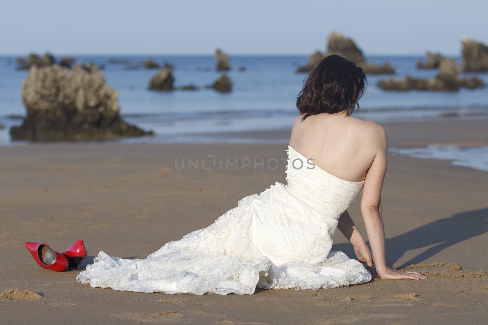 Bride drawing a heart on the sand.