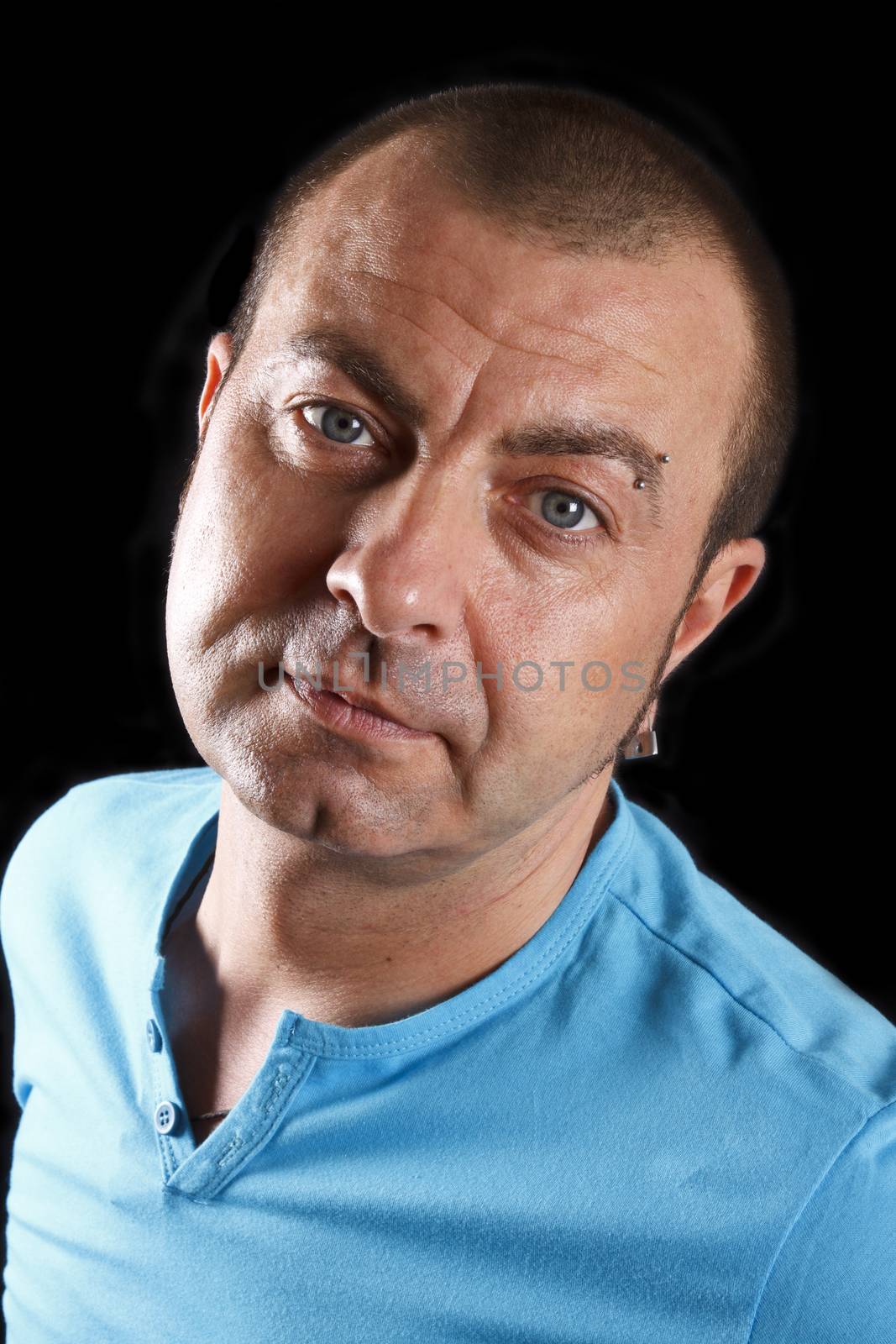 Portrait of handsome man with a blue t-shirt. Over black.