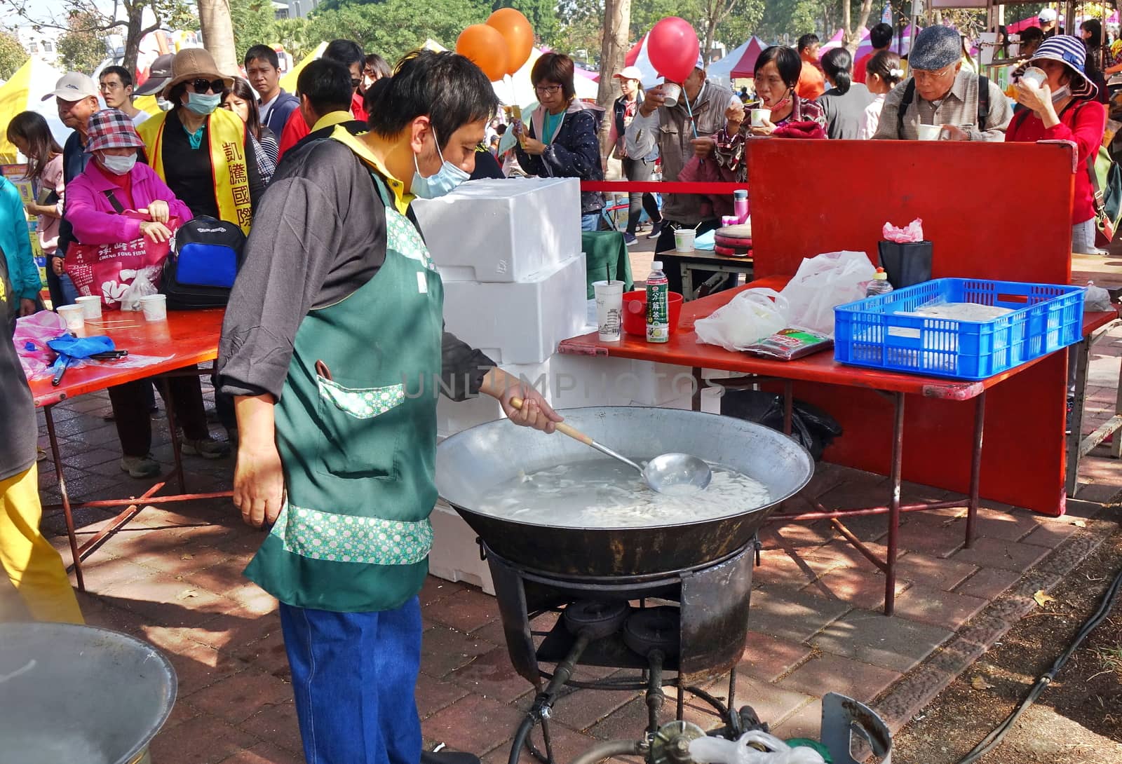 KAOHSIUNG, TAIWAN -- JANUARY 5, 2019: A man cooks fish soup in a large wok at the Luzhu Tomato Festival.
