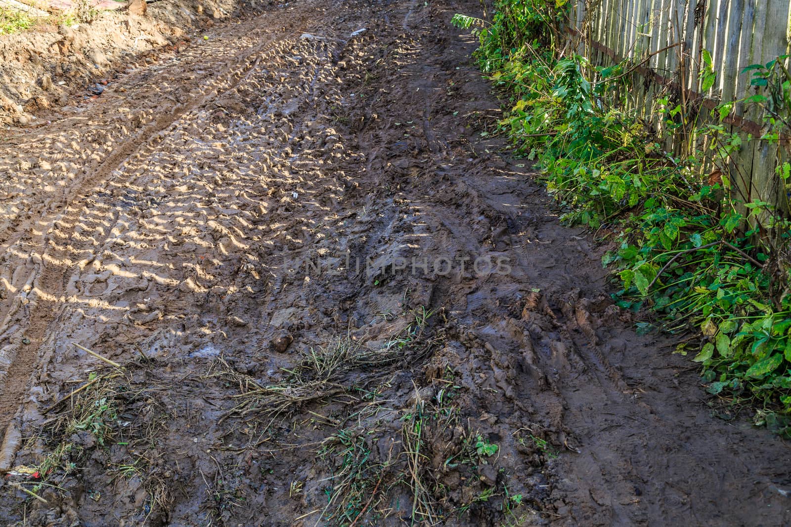 pavement in a provincial Russian city in poor condition, puddles and dirt