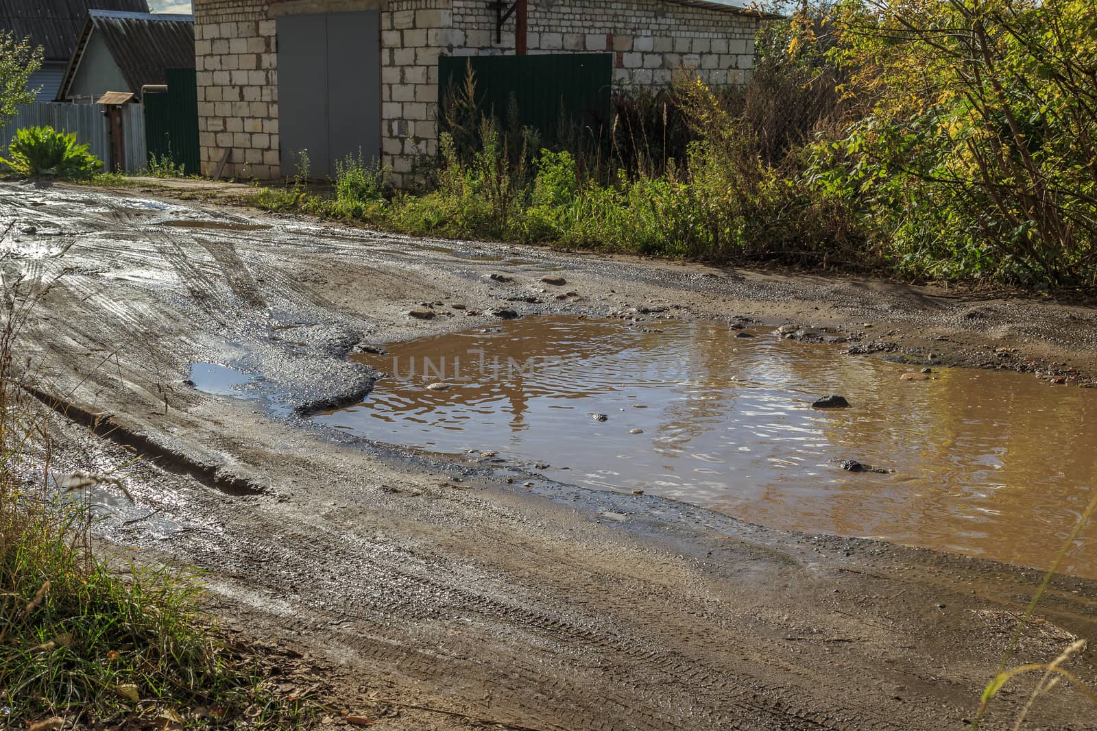 roadway in a provincial Russian city in poor condition, pits and dirt