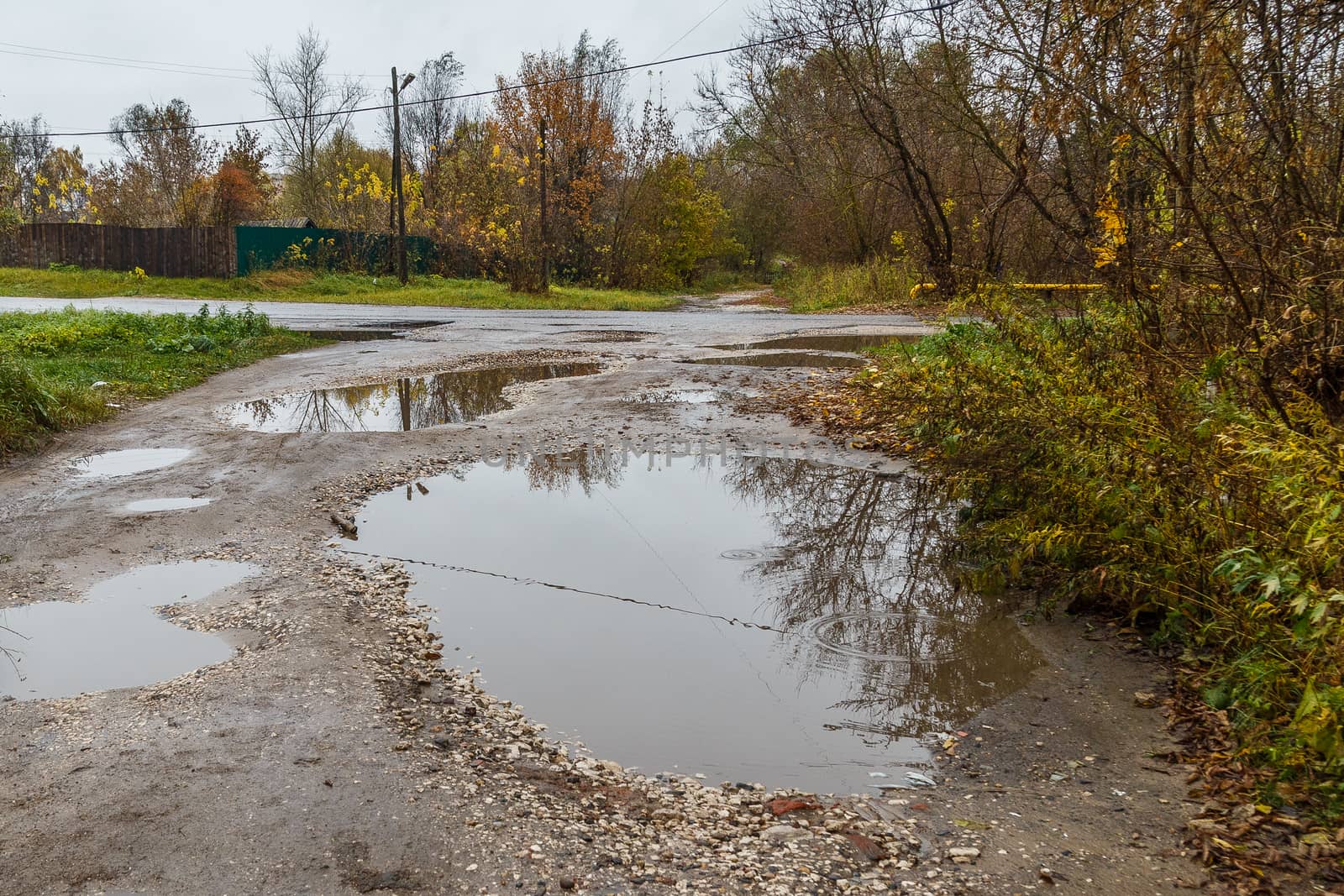 roadway in a provincial Russian city in poor condition, pits and dirt