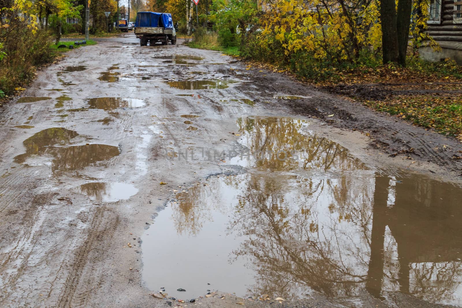 roadway in a provincial Russian city in poor condition, pits and dirt