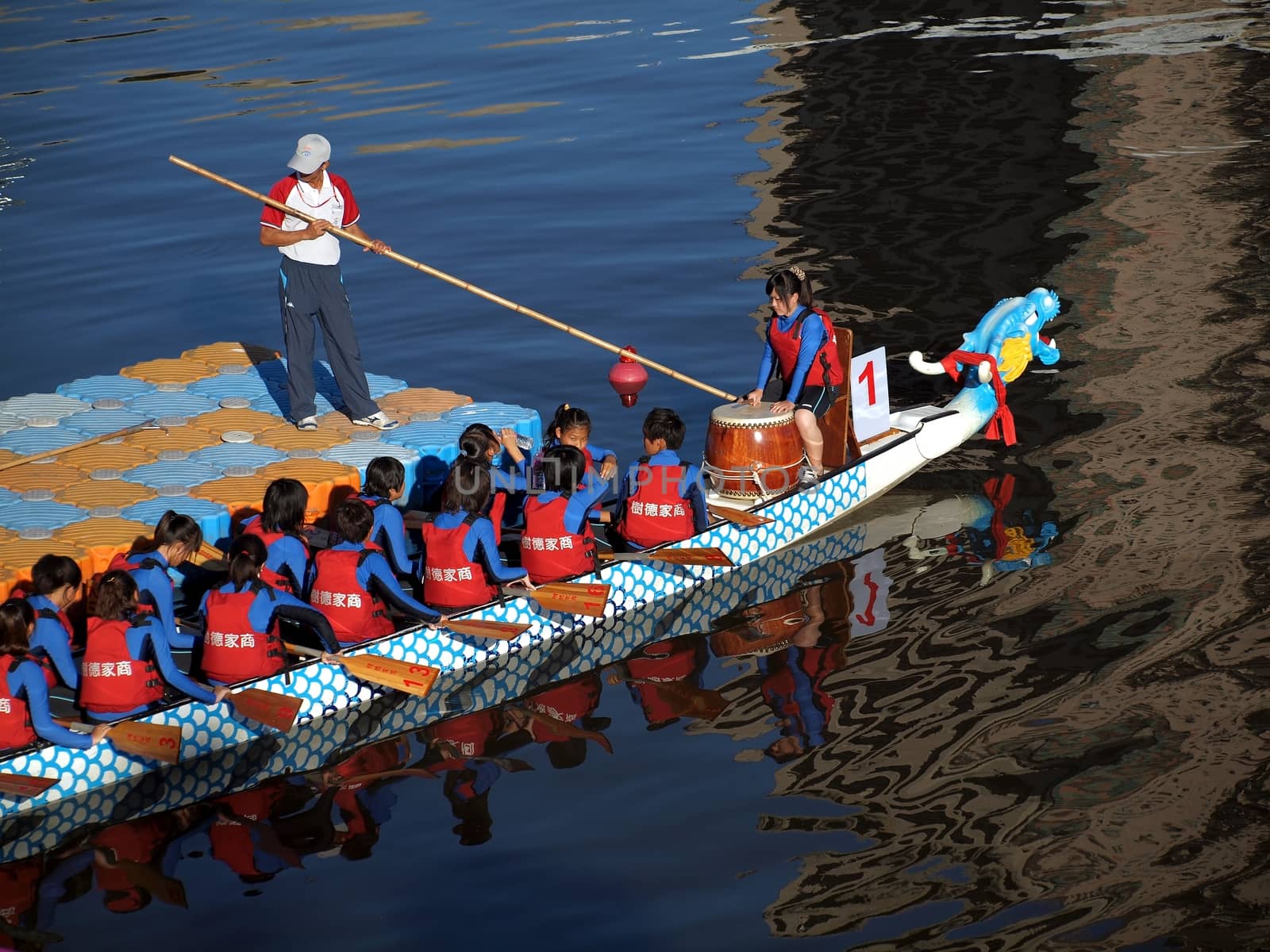 KAOHSIUNG, TAIWAN - JUNE 6: A team of female rowers waits at the starting line for the dragon boat race on the Love River on June 6, 2011 in Kaohsiung