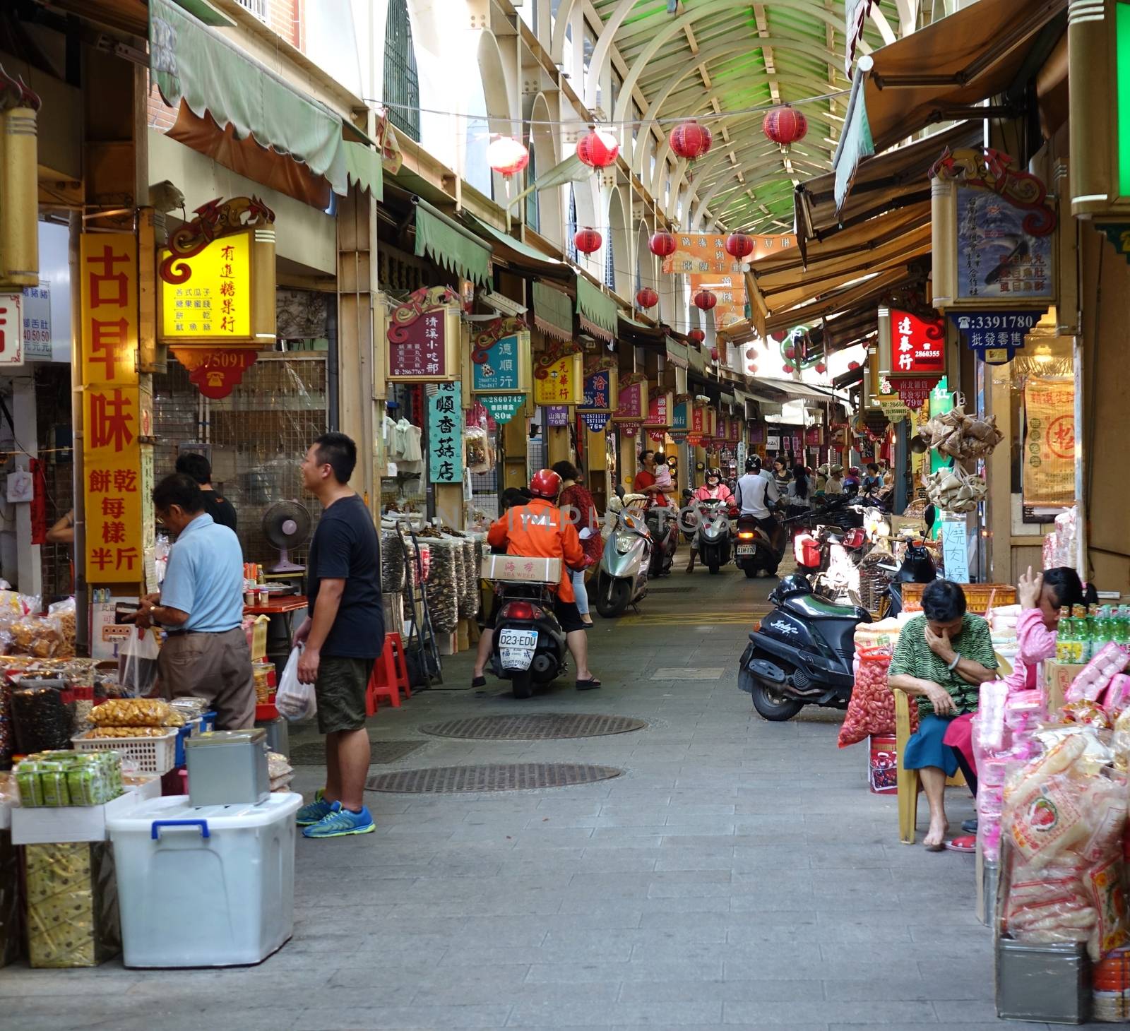 KAOHSIUNG, TAIWAN -- MAY 31, 2014: Shoppers buy goods at the famous Zongjie dry goods market which sells grains, nuts, dried meat, fish, seafood, herbs and fruits.