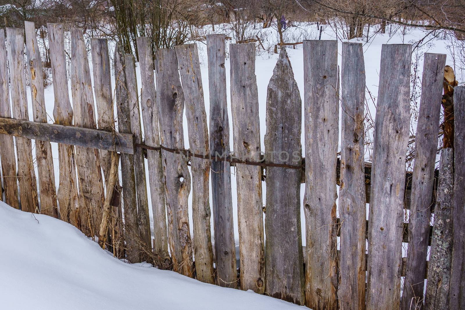 wooden fence of boards nailed to the crossbar  by VADIM