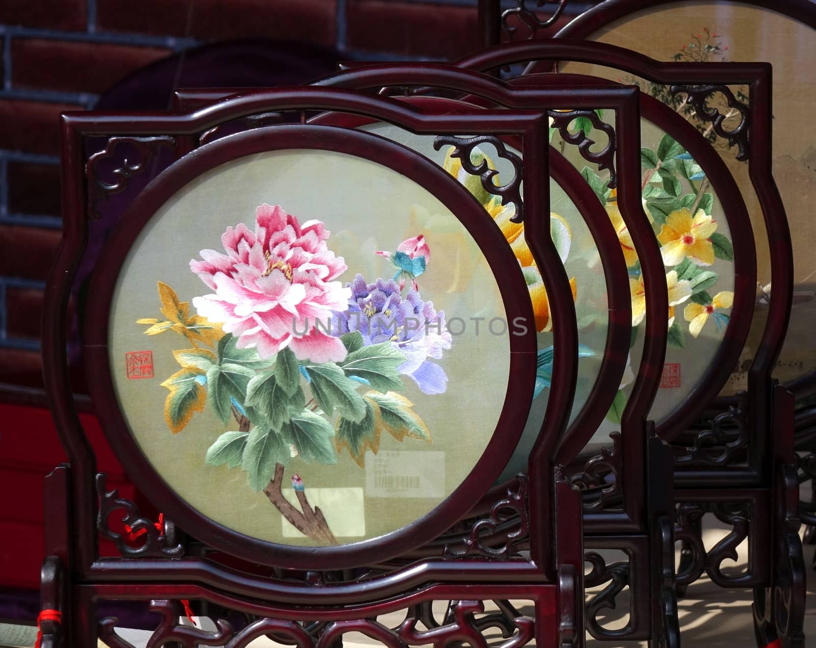 KAOHSIUNG, TAIWAN -- JANUARY 1, 2015: An outdoor vendor sells embroidered silk screens in wood framing, a popular Chinese art and craft product.
