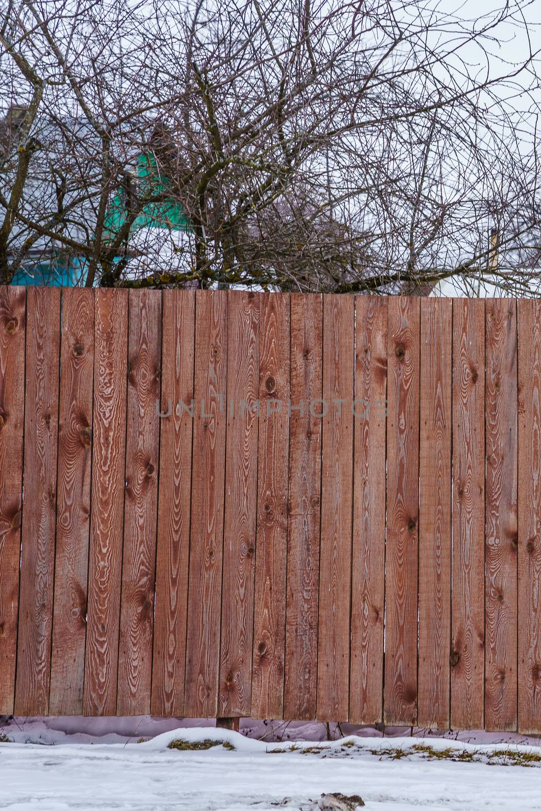 fence of red painted boards around the garden