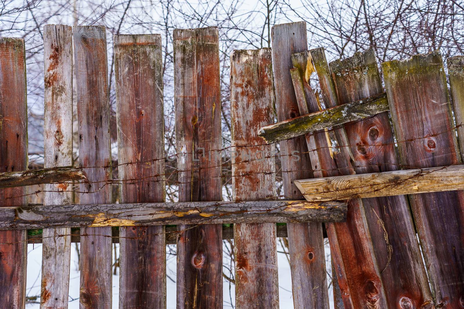 old fence from boards around the building, winter day
