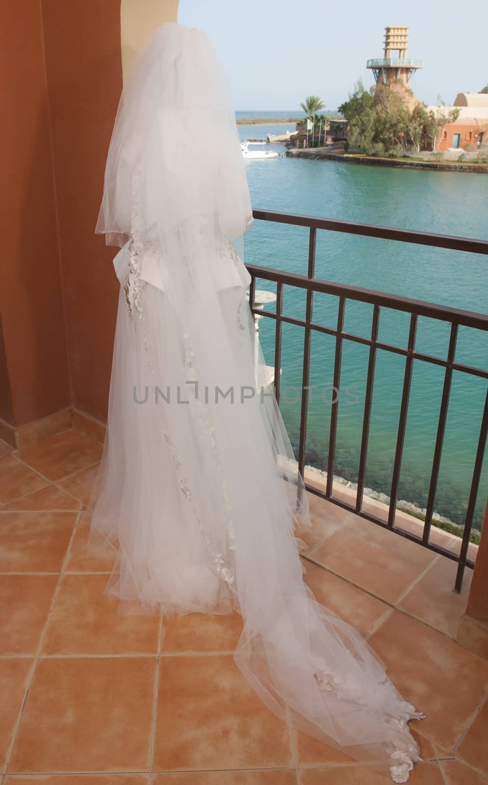 Bride stood on balcony in tropical coastal resort by paulvinten