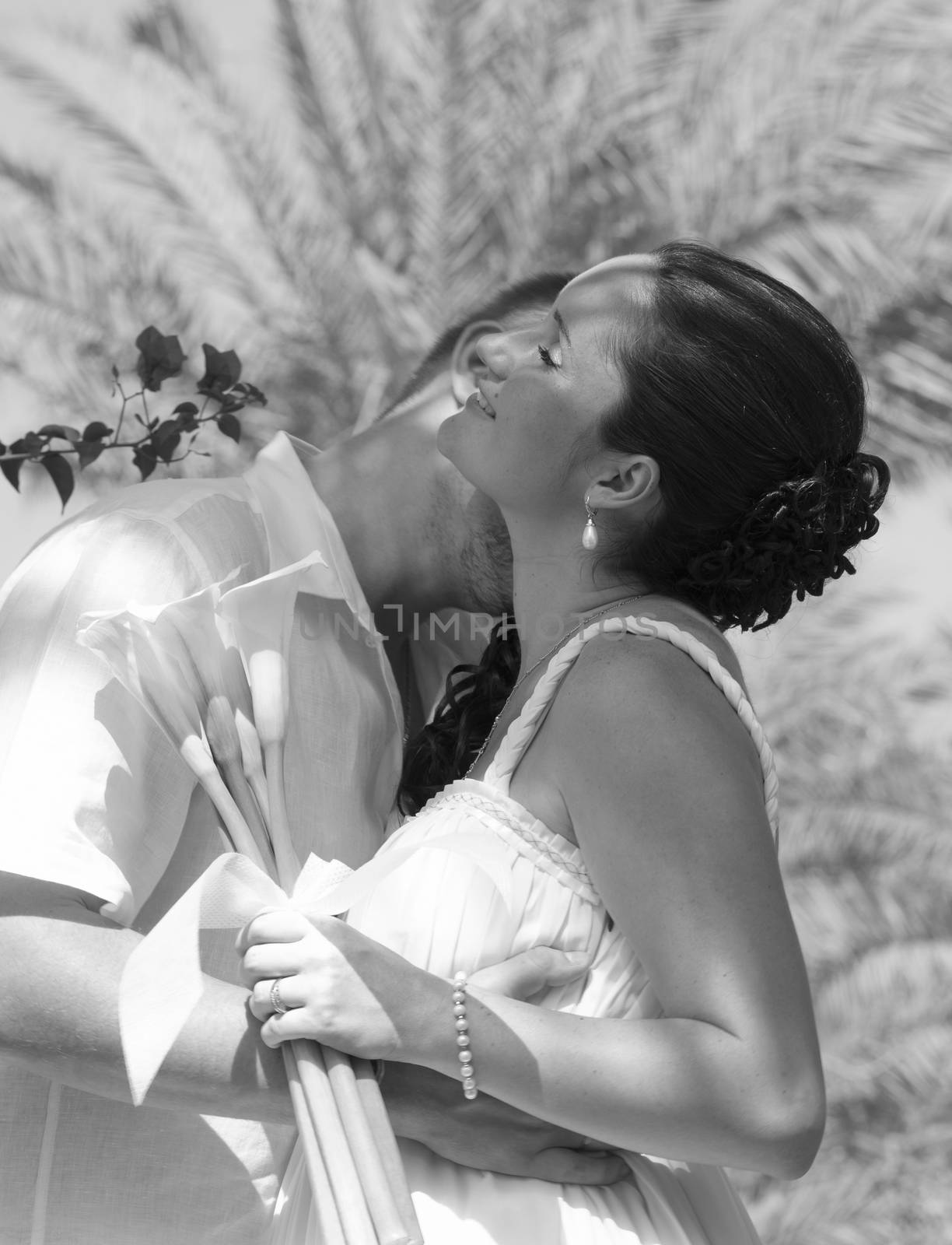 Newlyweds having a romantic kiss by paulvinten