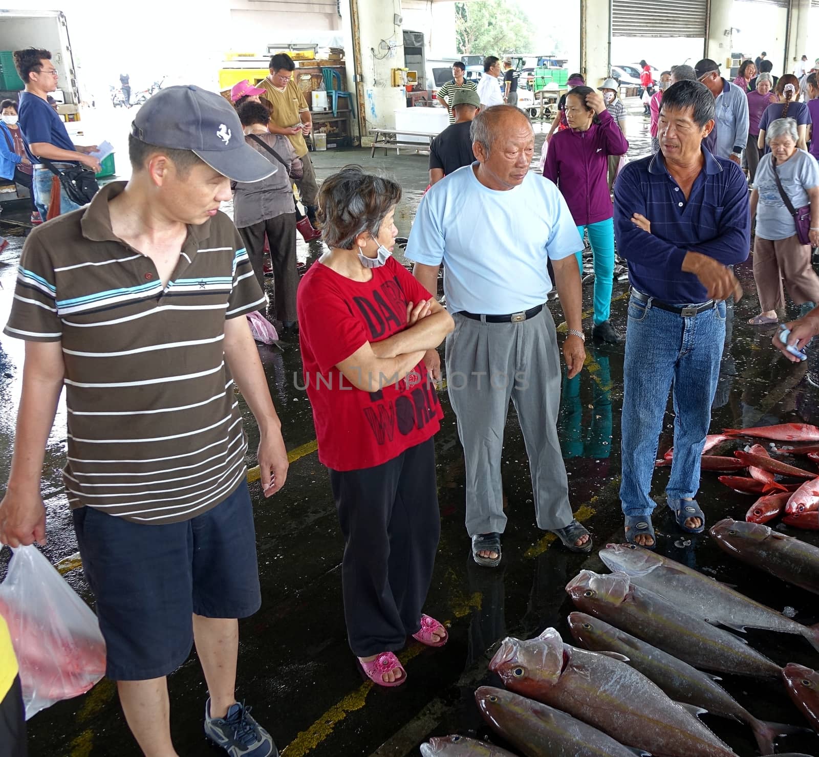 KAOHSIUNG, TAIWAN -- MAY 3, 2014: Prospective buyers bargain over fresh fish at Sinda Fishing Port.