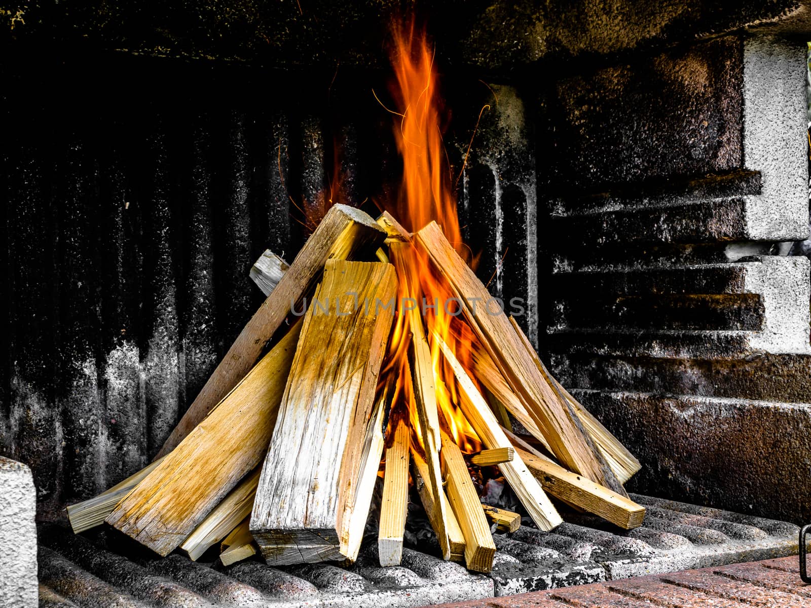Preparation of a BBQ - wood piled up - flames on the right