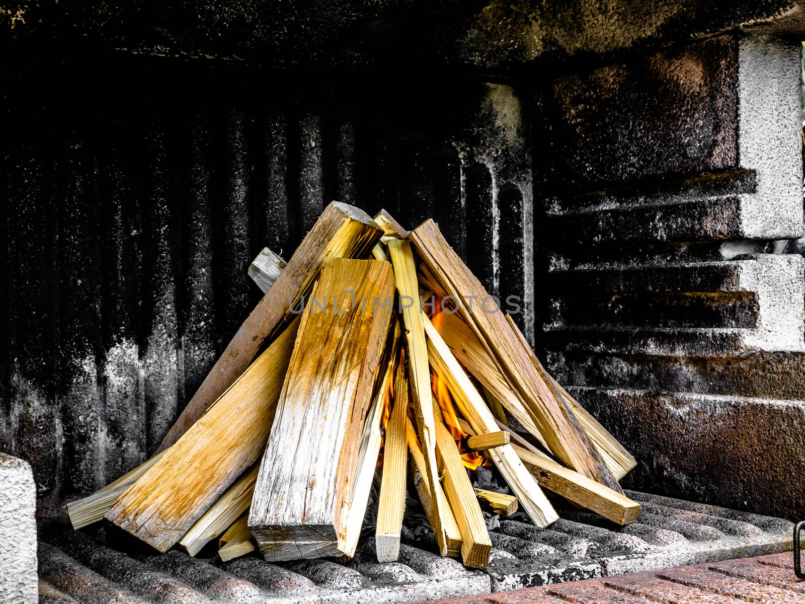 Preparation of a BBQ - wood piled up - fire starting to burn up on the bottom
