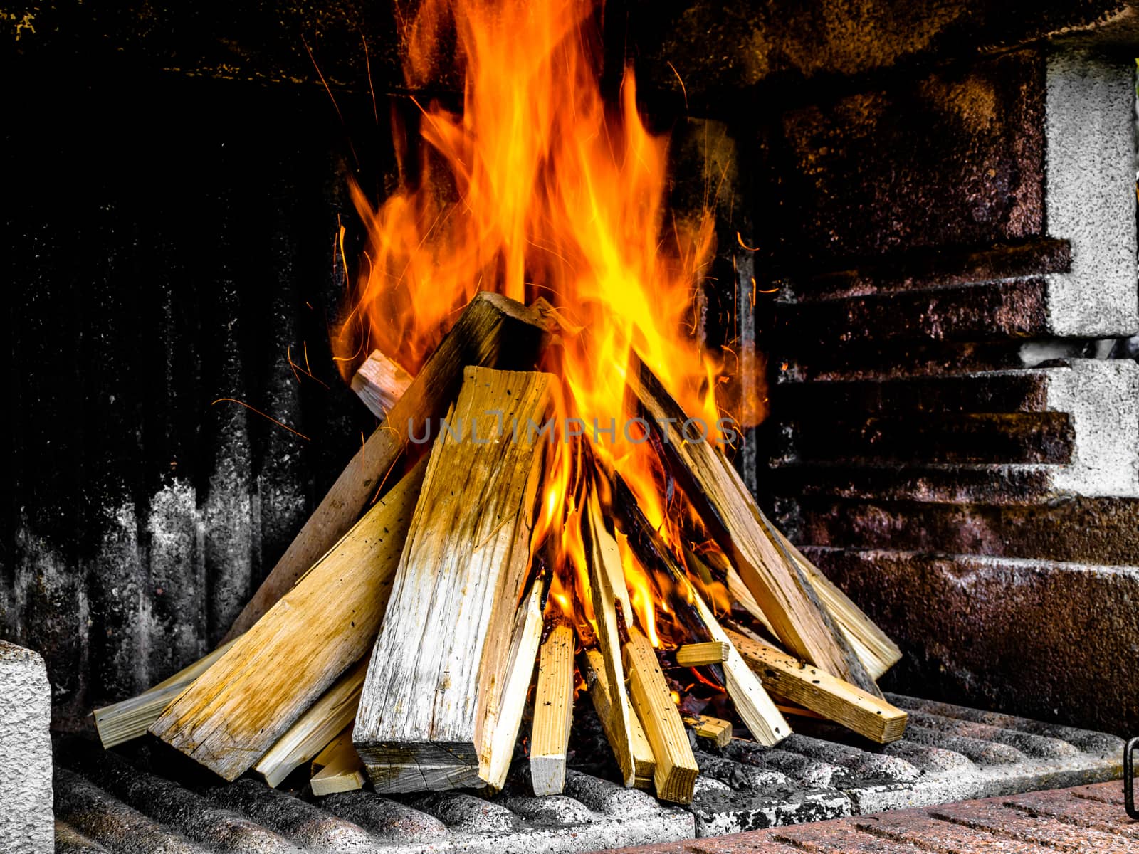 Preparation of a BBQ - wood piled up - fire reaching top of the pile